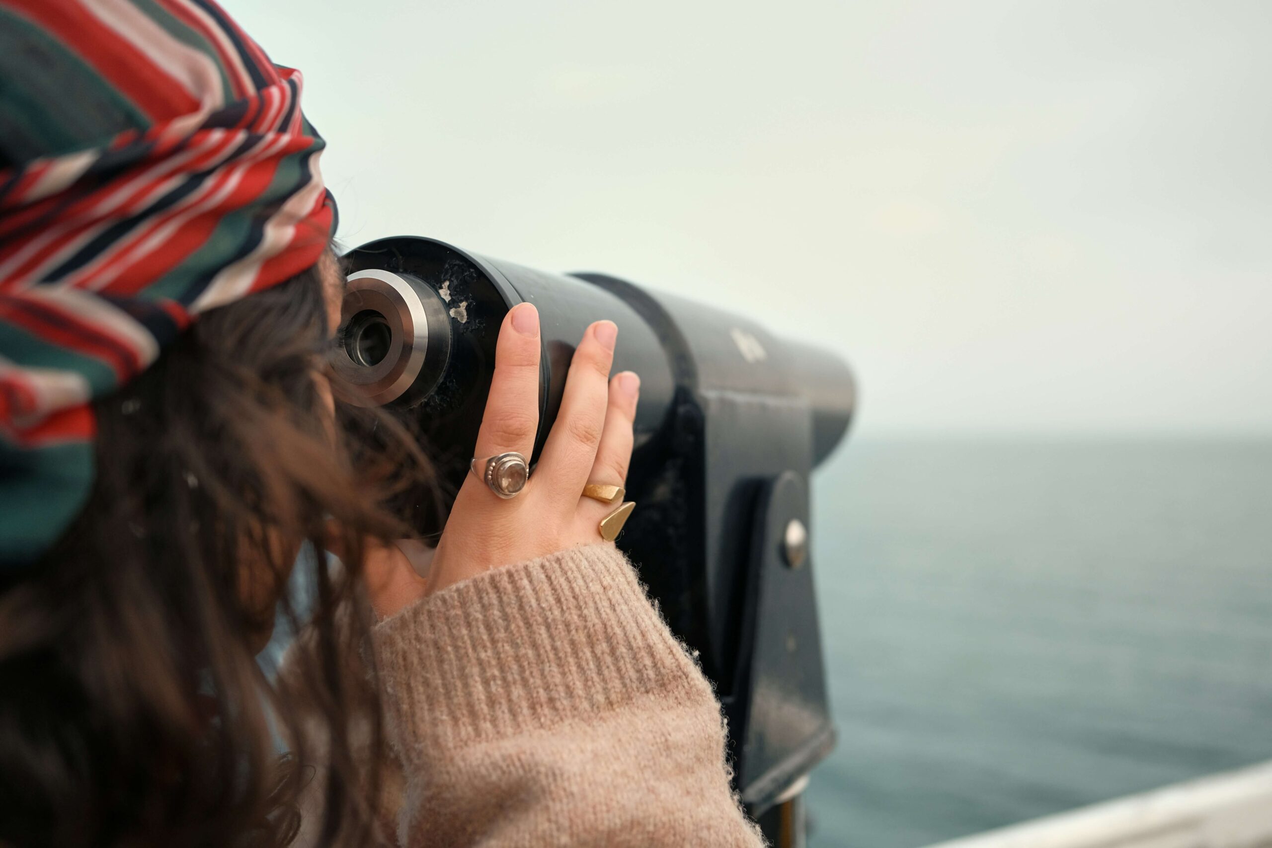 Woman looking at the telescope, showcasing adaptability skills of concern and curiosity to build a professional reputation and a long-lasting personal brand.