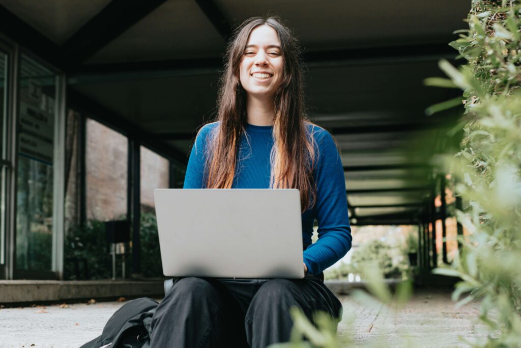 a woman completing the personal brand assessment on the laptop and smiling