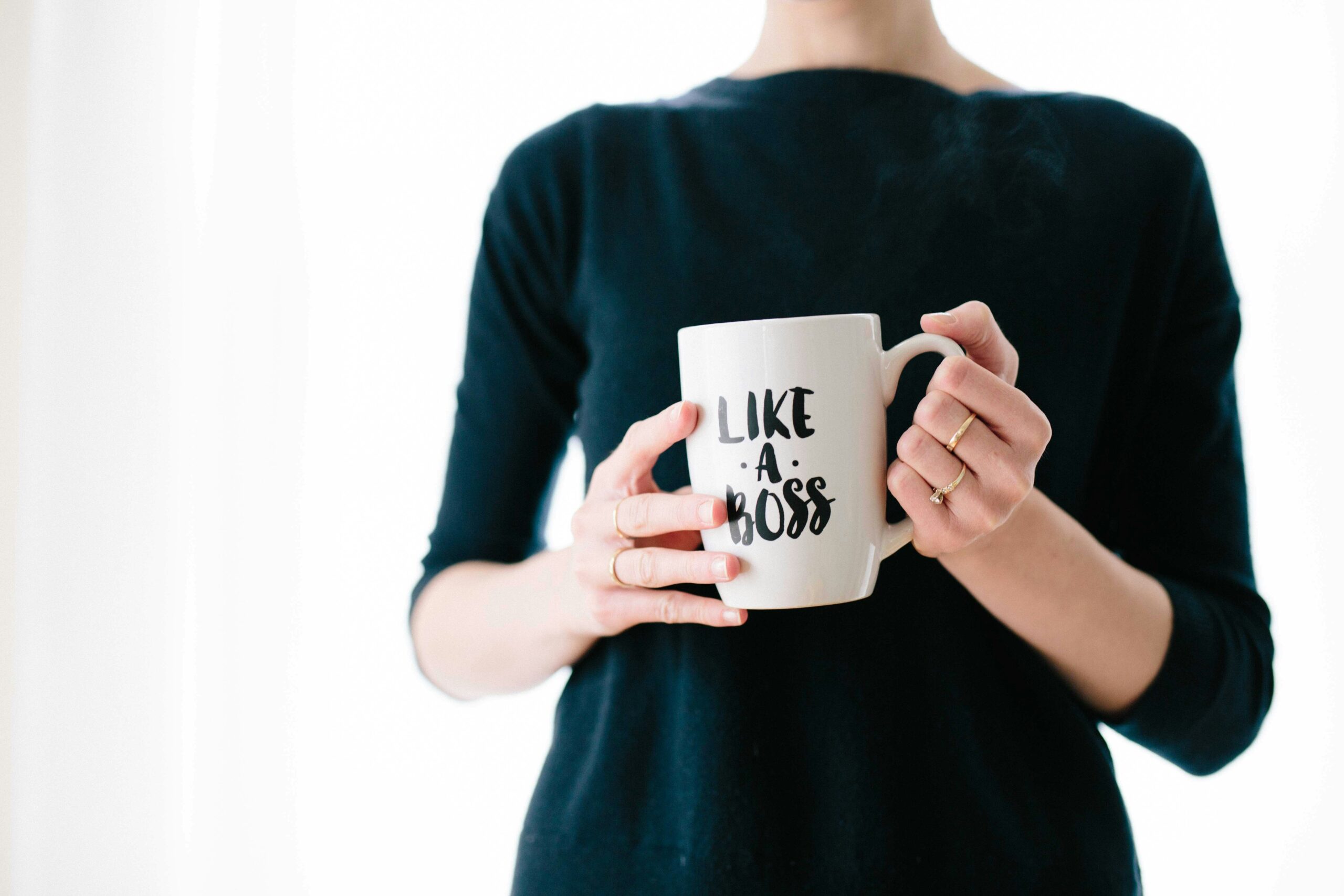 Professional holding a white mug with the phrase “Like a Boss,” symbolizing confidence, personal brand attributes, professional superpower, top strengths, and characteristics of high-potential employees.