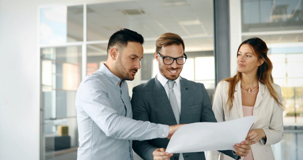 Professionals reviewing work outcomes in a corporate setting, symbolizing how expertise, reputation, and visibility shape value exchange, recognition, and career progression for mid-career professionals.